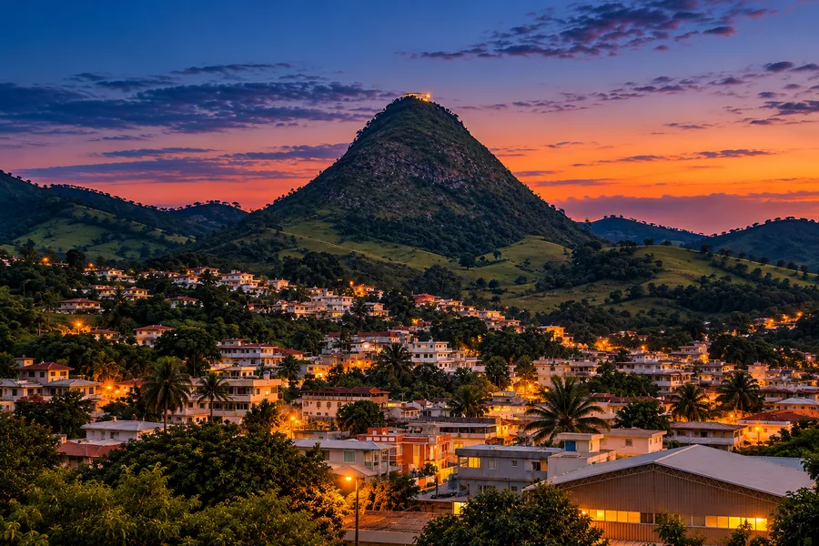 O sonho: a Pedra Bonita ao anoitecer, vista da cidade, com o mirante aceso no topo